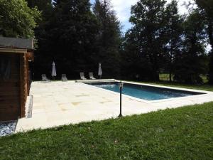 a swimming pool in a yard with chairs and trees at gitedubourghaut in Saint-Éloy-les-Tuileries