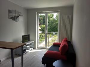 ein Wohnzimmer mit einem Sofa, einem Tisch und einem Fenster in der Unterkunft Apartament Sunny Day in Polanica-Zdrój