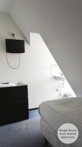 Habitación blanca con cama y lavamanos en Rembrandt Square Hotel, en Ámsterdam
