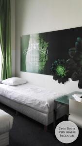 1 cama en una habitación con un cartel en la pared en Rembrandt Square Hotel, en Ámsterdam