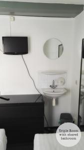 Un dormitorio con un lavabo y un espejo en la pared. en Rembrandt Square Hotel, en Ámsterdam