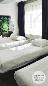 two twin beds in a bedroom with a window at Rembrandt Square Hotel in Amsterdam