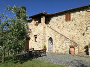 a stone building with a bench in front of it at Casa il Ponte in Chianni