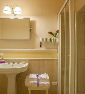 a bathroom with a sink and a mirror and a shower at Granduomo Charming Accomodation in Florence