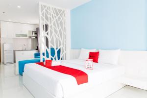 um quarto branco com uma cama com um cobertor vermelho em An Phuc House Doan Nhu Hai em Ho Chi Minh
