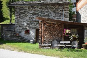 a stone building with two chairs and a table at Albergo Mangusta in Madesimo