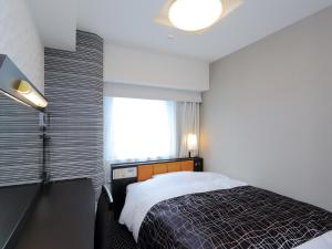 um quarto com uma cama grande e uma janela em APA Hotel Nagoya Sakae Kita em Nagoya
