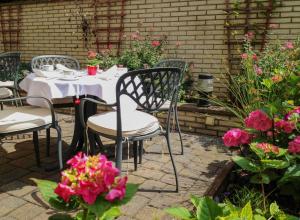 a table and chairs in a garden with pink flowers at Hotel Imperial in Cologne