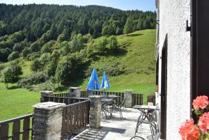 d'un balcon avec des tables et des parasols bleus sur une colline. dans l'établissement Albergo Mangusta, à Madesimo