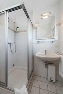 ein Bad mit einer Dusche und einem Waschbecken in der Unterkunft Haus Pamir - Fewo 27 in Cuxhaven