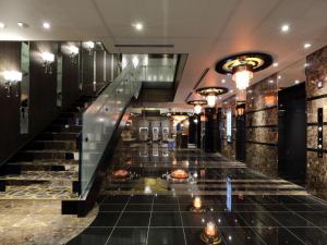a lobby of a hotel with stairs and lights at APA Hotel Nagoya Sakae Kita in Nagoya