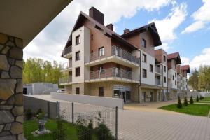 ein großes Gebäude mit einem Zaun davor in der Unterkunft Apartament Sunny Day in Polanica-Zdrój