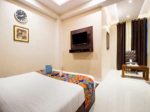 a hotel room with a bed and a tv at FabExpress Travelers Lodge in Jaipur