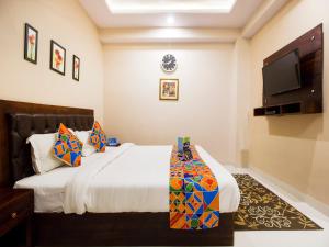 a bedroom with a bed and a flat screen tv at FabExpress Travelers Lodge in Jaipur