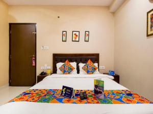 a bedroom with a large bed with colorful pillows at FabExpress Travelers Lodge in Jaipur