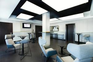 a waiting room with chairs and tables and skylights at Hotel Kossak in Krakow