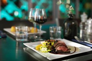 a plate of food on a table with wine glasses at ProfilHotels Aveny in Umeå