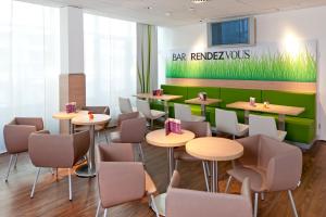 ein Restaurant mit Tischen und Stühlen und ein Schild mit abgestrahlten Wölfen in der Unterkunft ibis Augsburg Hauptbahnhof in Augsburg