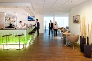 a group of people standing around a bar in a restaurant at ibis Augsburg Hauptbahnhof in Augsburg