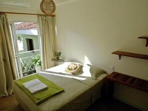 a bedroom with a bed with a large window at Zen Hostel Brasil in Sao Paulo