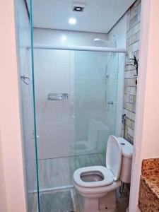 a bathroom with a toilet and a shower stall at Zen Hostel Brasil in Sao Paulo