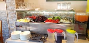 a buffet of food with plates and fruit and juice at Apartments Monte Wiena in Ulcinj