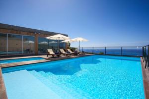 a swimming pool with a view of the ocean at Mosteiros Place in Mosteiros
