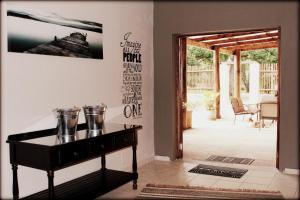 a room with a piano and a door to a patio at Aqua Terra Guest House in Lydenburg