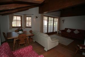 a living room with a white couch and a table at Villetta ai Pini Deluxe in Canazei