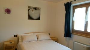 a bedroom with a white bed and a window at Agriturismo da Ysy in Civo