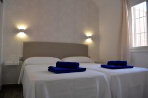 two beds in a room with blue towels on them at The Peaches Bungalows 45 & 46 in Maspalomas +10 photos