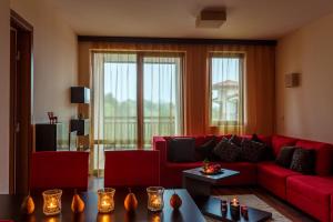 a living room with a red couch and red chairs at Top Apartment in Bansko in Bansko