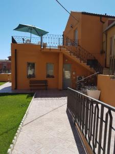 uma casa com uma varanda com um banco e um guarda-chuva em Casa dei Talenti em Cagliari