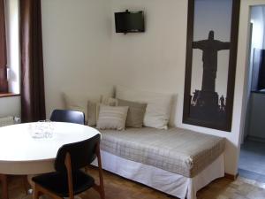 um quarto com uma cama com uma mesa e uma cruz na parede em Marcia Donatti-A l'Ombre des Coteaux Rio de Janeiro em Kaysersberg