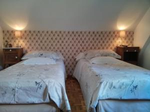 ケゼルスベールにあるMarcia Donatti-A l'Ombre des Coteaux Rio de Janeiroのベッドルーム1室(ベッド2台付)、壁にランプ2つ
