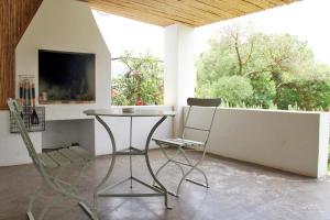 mesa y sillas en una habitación con ventana en Tanagra Wine & Guestfarm, en McGregor