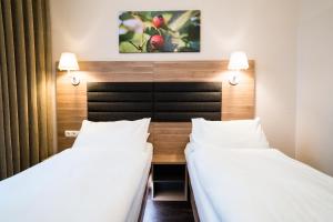 two beds in a hotel room with white sheets at Hotel Marc Aurel - Vienna City Center in Vienna +82 photos