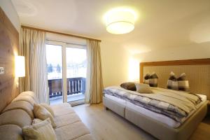 ein Schlafzimmer mit einem Bett und einem großen Fenster in der Unterkunft Apartment Haus Schatz in Kitzbühel