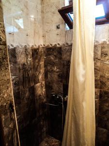 a bathroom with a shower with a shower curtain at Bacho,s Cottage in Borjomi
