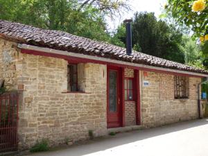 Balanodにあるgite le margueriteの赤い扉付きの小さな石造りの家