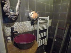 a bathroom with a red sink and a mirror at gite le marguerite in Balanod