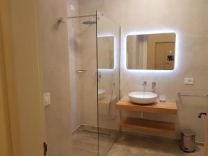 a bathroom with a sink and a glass shower at VILLA ROSA in Torre Suda +28 photos