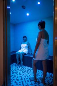 Eine Frau, die vor einem Mann im Bett steht. in der Unterkunft Hotel Goldene Traube in Coburg