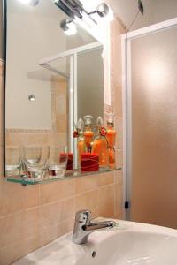 uma casa de banho com um lavatório, um espelho e um lavatório. em Camere Rufino em Collestrada