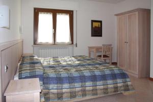 a bedroom with a bed and a window and a table at Camere Rufino in Collestrada