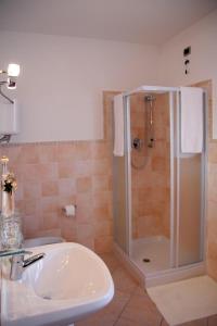 uma casa de banho com um chuveiro e um lavatório. em Camere Rufino em Collestrada