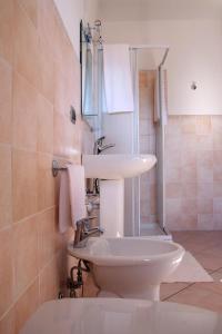 uma casa de banho com um lavatório branco e um chuveiro em Camere Rufino em Collestrada