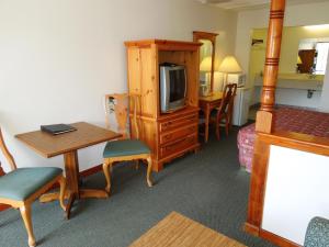 um quarto de hotel com uma mesa, uma televisão e uma secretária em Executive Lodge Absecon em Absecon