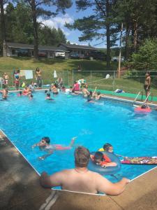 a group of people swimming in a swimming pool at Fair Isle Motel & The Nest in Whycocomagh