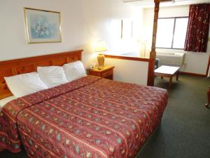a hotel room with a bed with a red bedspread at Executive Lodge Absecon in Absecon